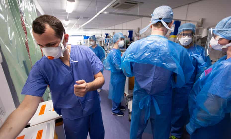 Doctors take off their PPE as they leave a Covid intensive care unit
