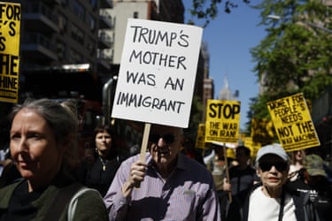 a person holds a sign that reads ‘Trump’s mother was an immigrant’