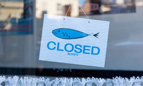 Closed sign in a fish and chip shop window.