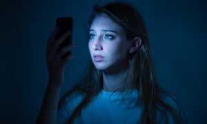 A young woman using an iPhone smart phone looking worried anxious concerned cyber bullying bullied on-line<br>D9KFGG A young woman using an iPhone smart phone looking worried anxious concerned cyber bullying bullied on-line
