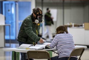 Robert Forrestal, left, wears a full face chemical shield to protect against the spread of coronavirus, as he votes Tuesday, April 7, 2020, at the Janesville Mall in Janesville, Wisconsin.