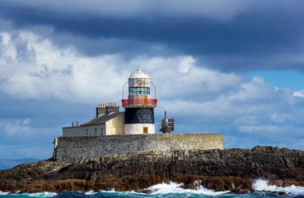 A lighthouse standing on rocks at Bantry Bay.