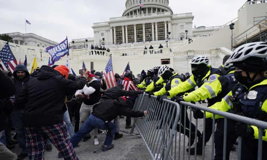 Members of a mob try to break through a police barrier at the US Capitol in Washington DC on 6 January. 