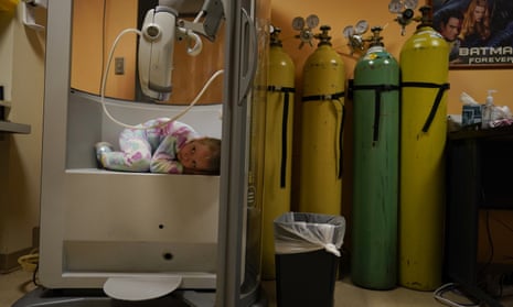 Lexie Stroiney, 6, curls up in the plethysmography chamber during a break in her pulmonary function test at Children's National Hospital in Washington on 26 January 2022. Lexie had Covid-19.