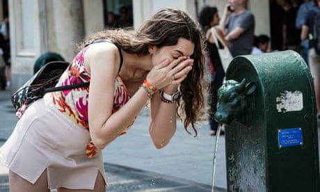 A woman cools off in a street water fountain in Turin on Saturday.