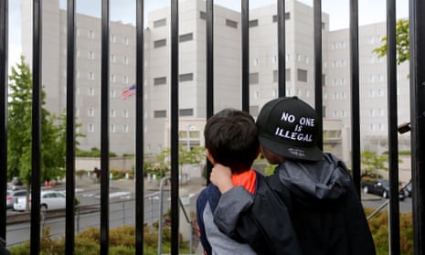 Javier Tapia, five, and his brother, Charlie Tapia, seven, originally from Mexico, stand outside a federal detention center holding migrant women on 9 June in Washington state.