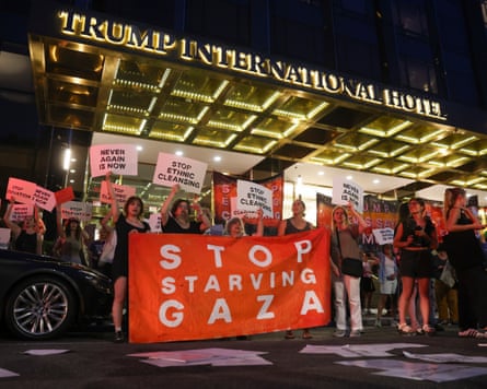 demonstration outside a hotel where protesters hold sign reading 'stop starving gaza'