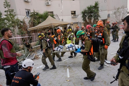 Israeli soldiers and rescue workers carry a body