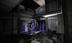 Residents walk past debris at the damaged American Quality Lodge where they continue to live in the aftermath of Hurricane Michael, in Panama City, Florida, on 16 October.