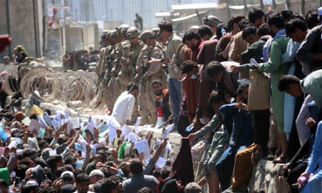 Afghans struggle to reach foreign forces to show their credentials to flee the country outside Kabul airport on 26 August 2021.
