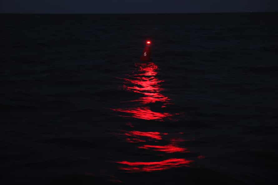 A buoy flashes red over the water to guide a ferry that connects two parts of Highway 12 between Hatteras and Ocracoke.