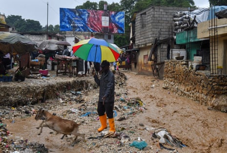 A person and their goat cross a flooded street after heavy rains caused by the outer bands of Hurricane Melissa flooded some areas, in Port-au-Prince, Haiti, October 29, 2025.