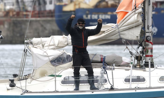 Juan Manuel Ballestero stands on his boat in Mar del Plata, Argentina, Thursday, June 18, 2020. Ballestero crossed the Atlantic on a small sailboat, setting off from the port of Porto Santo in Portugal on March 24 and finally reaching Mar del Plata on Wednesday to be reunited with his parents after flights to Argentina were cut due to the COVID-19 lockdown. (AP Photo/Vicente Robles)