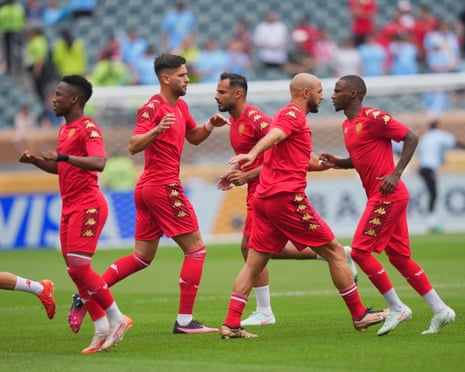 Wydad players warm up in front of empty seats.