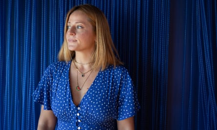 Iva Divic-Baetens in a blue dress standing against a blue backdrop