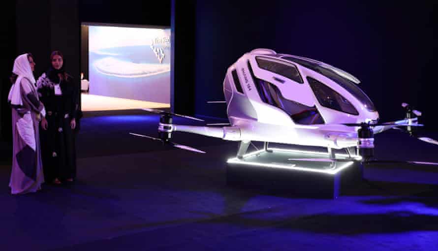 Visitors stand next to a drone taxi during an exhibition on Neom in Riyadh