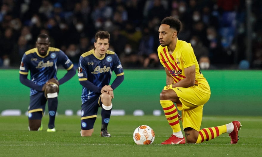 Barcelona’s Pierre-Emerick Aubameyang takes a knee, as do two Napoli players before their Europa League match.
