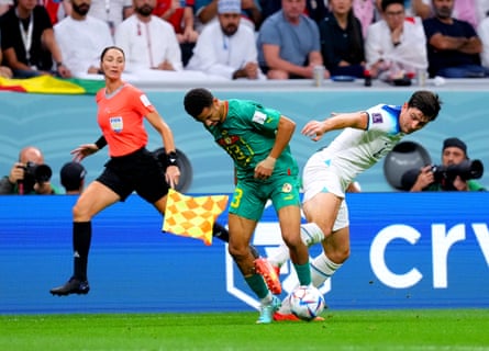 Assistant referee Kathryn Nesbitt looks on as Senegal’s Iliman Ndiaye (centre) and England’s Harry Maguire battle for the ball during the 2022 World Cup round of sixteen match.