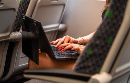 A woman uses a laptop on a train