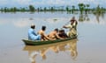 People use a canoe to move across flooded land.