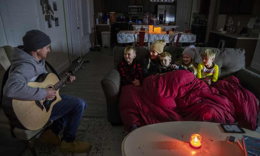 Brett Archibald tries to entertain his family as they attempt to stay warm in their home the BlackHawk neighborhood in Pflugerville, Texas, last week.