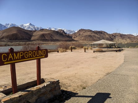 wooden sign says ‘campground’, with mountains in distance