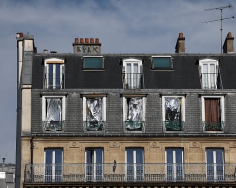 The windows of a Haussmann-style residential building are seen covered with emergency blankets to shield them from the sun in Paris, France.