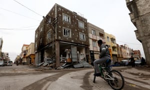 A child sits on his bicycle in front of a house damaged by a rocket fired from Syria, in Kilis, 21 January 2018