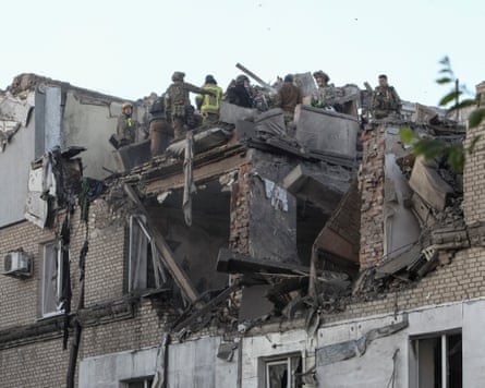 Firefighters on top of a damaged residential building