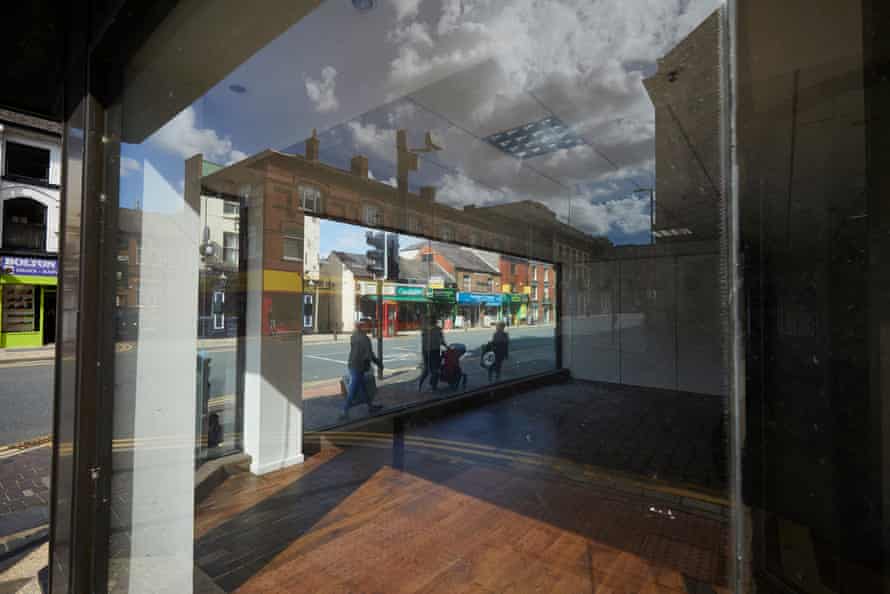 A shopping street seen through the window of the recently closed Beales department store, previously known as Whitakers.