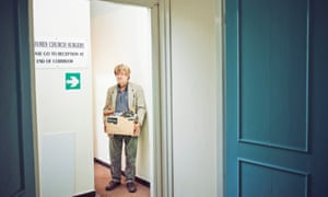Dr Zigmond holding a box and looking glum as he packs up his surgery
