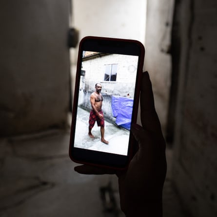 A person holds a phone showing a photograph of onaldo Julião da Silva