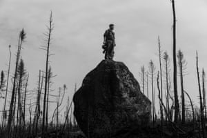 Theo Dagnaud scans the horizon from the top of a rock to ensure that firefighter patrols have left, and he can mark the area as 'controlled'. Quebec, Canada, 13 July 2023