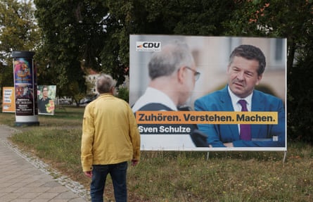 A man looks at an election campaign billboard that shows Saxony-Anhalt premier Sven Schulze of the Christian Democratic Union and reads: ‘Listen. Understand. Do.’
