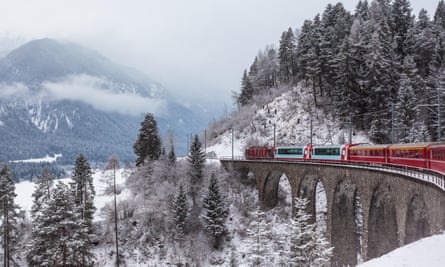 Famous sightseeing train running over viaduct in Switzerland, the Glacier Express in winterG0TX2B Famous sightseeing train running over viaduct in Switzerland, the Glacier Express in winter
