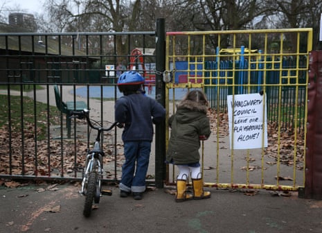  Children look into a closed playground next to Battersea Park in London, England. 