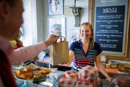Jesse d’Ambrosi serves a customer from behind the counter of her shop