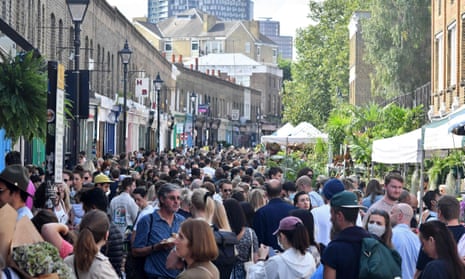 Crowds of people walk along Columbia Road flower market in east London last month