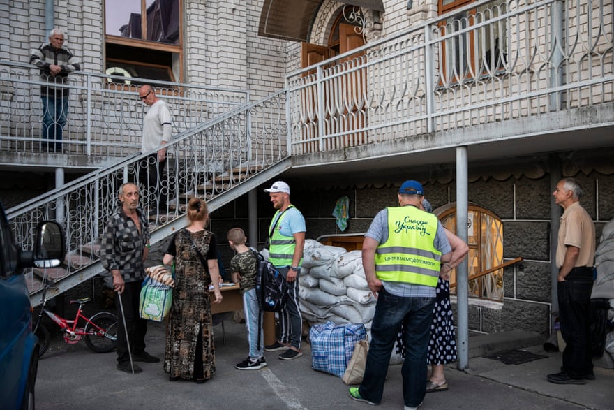Svitlana and Danylo with their backs to the camera as they register at an IDP shelter at the Light of the Gospel Church in Dnipro.