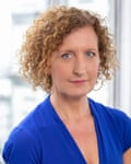 A curly-haired Lenore Anderson wearing a blue garment looks at the camera.