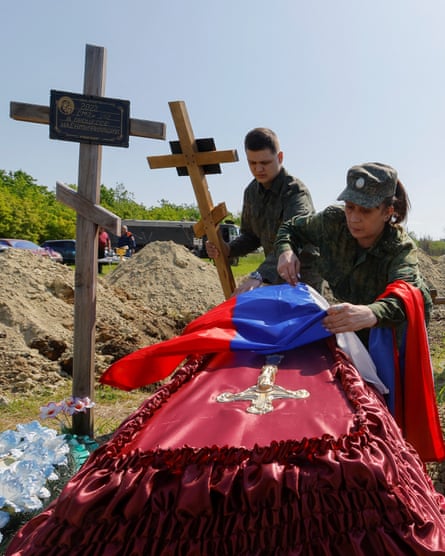 Two Russian soldiers preparing the grave for the coffin of a comrade