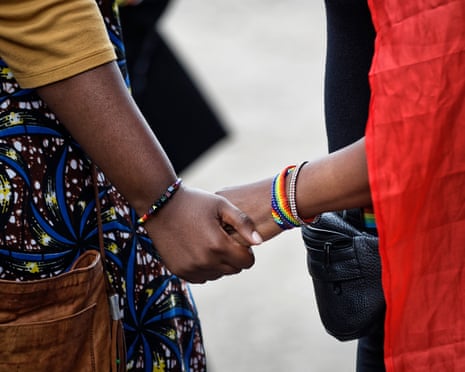 Two activists from the LGBTQ+ community hold hands following a court hearing in Kenya