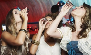 Some women drink some shots in a bar