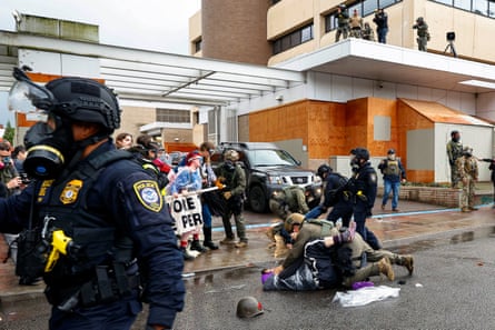 Law enforcement officers detain protesters during a protest activity in Portland