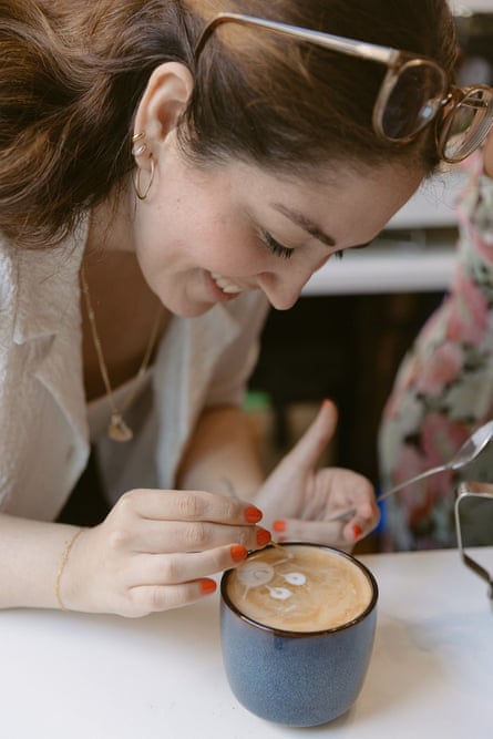 A girl puts the finishing touches to a latte
