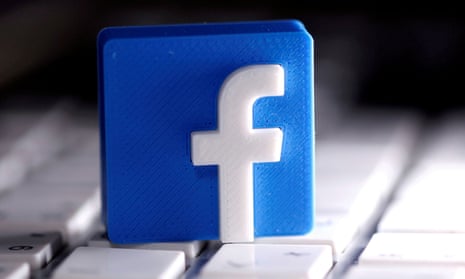A 3D-printed Facebook logo is seen placed on a keyboard