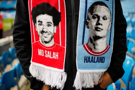 A fan wears a half and half scarf featuring Liverpool's Mohamed Salah and Manchester City's Erling Haaland.