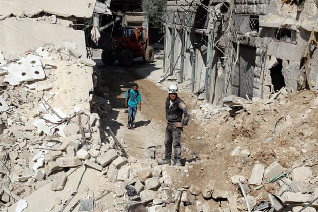 Residents and civil defence staff inspect a site damaged by an airstrike in the rebel-held al-Qaterji neighbourhood.