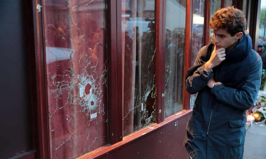 A man looks bullets impacts in the ‘Carillon’ restaurant, one of the site of the attacks in Paris, the day afte.