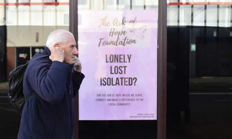 A man walks past a sign reading ‘Lonely, lost, isolated?’ in Stoke-on-Trent